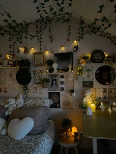 a living room filled with furniture and lots of plants hanging from the ceiling above it