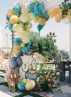 a winnie the pooh birthday party with balloons and decorations