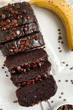 slices of chocolate banana bread on a plate next to a bowl of chocolate chips and a banana