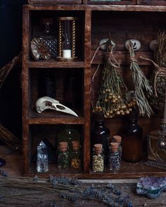 an old wooden shelf filled with bottles and herbs