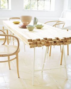 a table with chairs and plates on it in front of a poster that has been placed on the wall