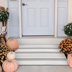 front porch decorated with pumpkins and flowers