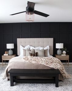 a bedroom with black walls and white bedding