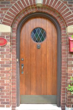 a wooden door is shown in front of a brick building