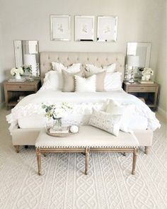 a bed with white sheets and pillows in a bedroom next to two pictures on the wall