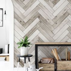 a wooden wall with white and grey herringbones in the background, next to a small table