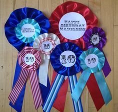 four ribbons with the words happy birthday and two are on a wooden floor next to each other