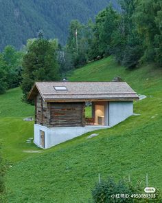 a small wooden cabin sitting on top of a lush green hillside