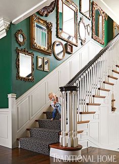 a staircase with mirrors on the wall and pictures on the wall above it in a home