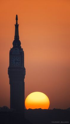 the sun is setting behind a clock tower