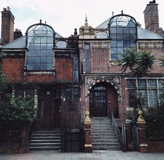 an old brick building with arched windows and stairs leading up to the front door area