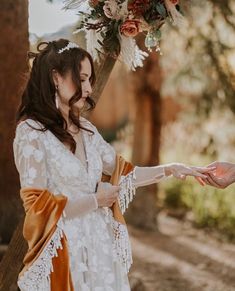 two women dressed in white holding hands