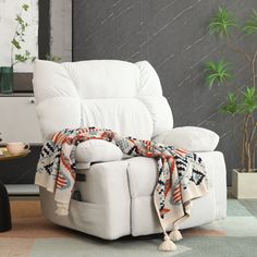 a white recliner chair with a blanket on it's back in a living room