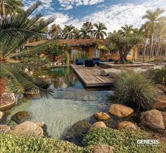 an outdoor pool surrounded by rocks and palm trees