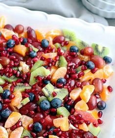 a white plate topped with fruit salad on top of a table