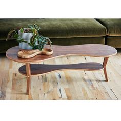 a wooden table sitting on top of a hard wood floor next to a green couch