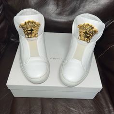 Womens High Top Versace Sneakers. All White With Large Gold Medusa Head. I Have The Original Box And Receipt As Pictured Very Good Condition Luxury High-top Sneakers In Calf Leather With Round Toe, Luxury High-top Sneakers With Leather Sole, Luxury White High-top Sneakers With Leather Sole, Luxury High-top Sneakers With Leather Sole And Round Toe, Luxury Calf Leather Slip-on Sneakers, Luxury Gold Custom Sneakers With Round Toe, Gold Dress Shoes Men, White And Gold Dress, Corridos Vip