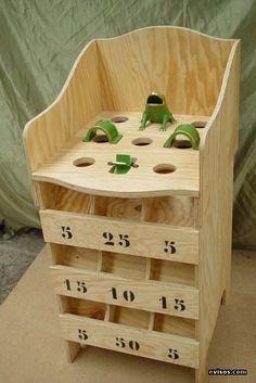 a wooden toy chest with numbers and frog figurines on it's sides