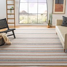 a living room with a couch, chair and rug in front of a large window