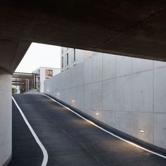 an empty street under a bridge next to tall buildings