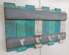 a wall mounted coat rack made out of wooden planks and painted with blue paint