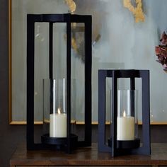 two black lanterns sitting on top of a wooden table