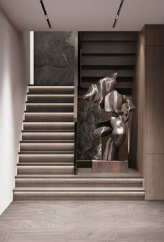 the stairs are lined with metal sculptures in front of them and there is also a marble wall