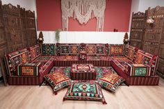 a living room filled with lots of furniture and rugs on top of wooden floors