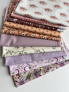 a stack of different colored fabrics on top of each other in various sizes and colors