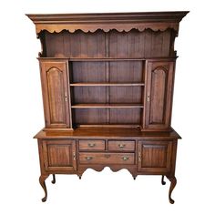 an old fashioned wooden cabinet with drawers and cupboards on the front, against a white background