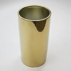 a gold colored cup sitting on top of a white table