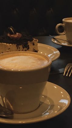 a cup of coffee with a piece of cake in the middle on a saucer