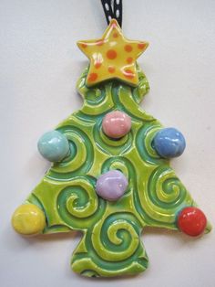 a ceramic christmas tree ornament hanging on a wall