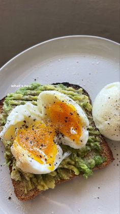 an egg and avocado toast on a white plate