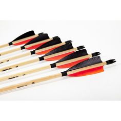 six arrows with black and orange tips are lined up in a row on a white surface