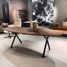 a wooden table sitting on top of a white floor next to a couch and chair