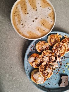 some food is on a blue plate next to a cup of coffee