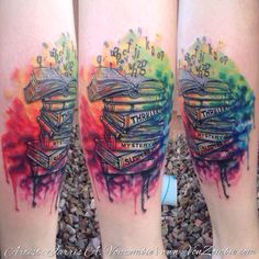 two tattoos with books on their legs that are covered in watercolors and ink