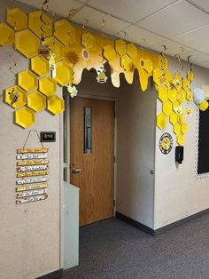 an office hallway decorated with yellow honeycombs and paper decorations hanging from the ceiling