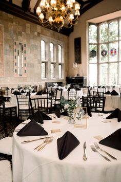 Elegant table setting for a wedding reception, featuring black napkins, gold silverware, and floral centerpieces at a timeless venue with large windows and stained glass accents. The beautiful chandelier and sophisticated decor create a classic and romantic atmosphere, perfect for capturing stunning reception photos. Reception Photography, Wedding Reception Photography, Elegant Wedding Reception, Photography Styles, Wedding Photography Styles, Wedding Day Timeline, Last Dance, Wedding Receptions