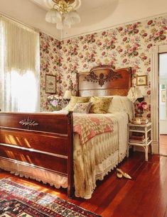 a bedroom with floral wallpaper and wooden floors