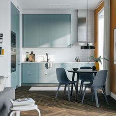 a kitchen and dining area with blue chairs, white counter tops and wood flooring