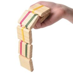 a hand holding wooden blocks with colored ribbons on them