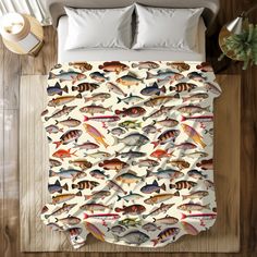 a bed covered in a white comforter next to a wooden floor with fish on it