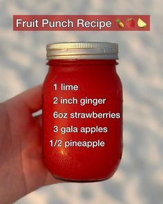 a hand holding a red mason jar with instructions for how to make fruit punch recipe