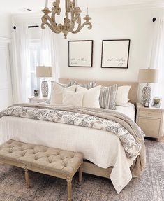 a bed room with a neatly made bed and a chandelier