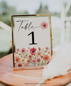 a table number sign with flowers on it