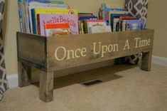 a wooden sign that says once upon a time with books in it on the floor