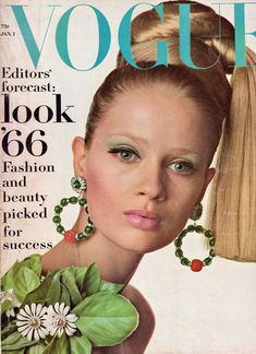 a magazine cover with a woman wearing green jewelry and flowers in her hair on the cover