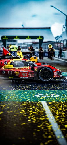 a red and yellow race car is on the street with confetti all over it